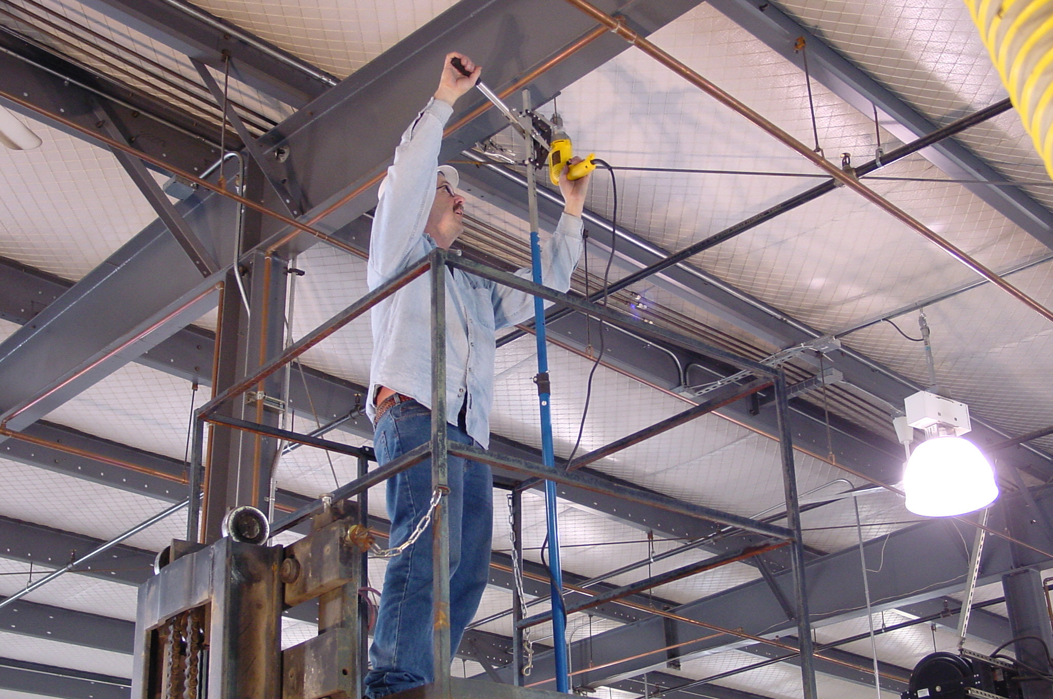 Overhead Drilling Overhead drilling into a steel beam while standing on a lift